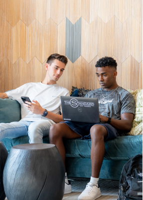 Two men sitting and looking at a laptop